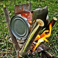 a tin can sitting on top of a fire in the grass