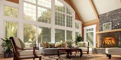 a living room filled with furniture and a fire place in the middle of an open floor plan