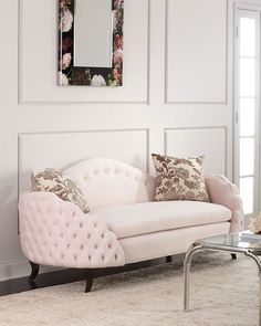 a living room with a white couch and mirror on the wall