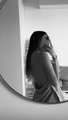 a woman standing in front of a mirror brushing her teeth