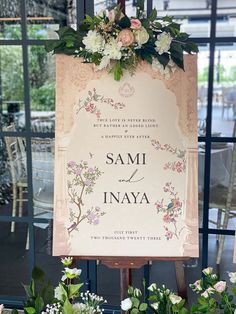 a sign with flowers on it in front of a window that says sami and inaya