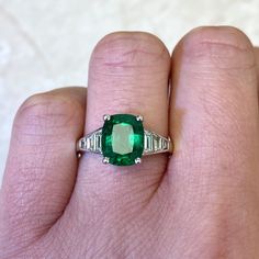 This stunning gemstone ring features a green cushion cut natural emerald, GIA-certified as 2.48 carats with great saturation. The emerald is prong-set in 18k white gold. Tapered baguette cut diamonds adorn the shoulders of this ring.
The total approximate diamond weight in this ring is 0.53 carats. The center emerald measures 9.36mm x 7.67mm x5.46mm.
If you have any questions about our Madison Ring, please contact us. Estate Diamond Jewelry, Green Cushions, Stunning Engagement Ring, Emerald Engagement, Baguette Cut Diamond, Emerald Engagement Ring, Perfect Engagement Ring, Vintage Engagement, Baguette Cut