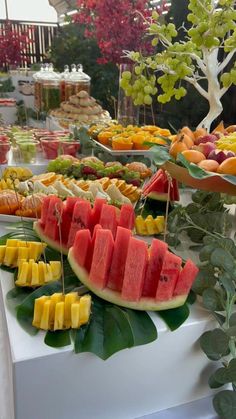 a table filled with lots of different types of fruit on it's trays