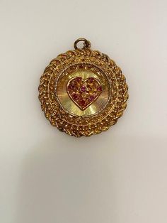 Vintage 14k yellow gold ruby heart round filigree disc with rope edge charm. The charm is 14.98 grams of gold. Gold-plated Heart Charm Jewelry, Gold Plated Heart Charm Jewelry, Gold Heirloom Jewelry For Valentine's Day, Victorian 14k Gold Jewelry For Valentine's Day, Victorian Medallion Jewelry With Heart Charm, Engraved Yellow Gold Medallion Charms, Collectible Yellow Gold Necklace With Heart Charm, Vintage 14k Gold Coin Pendant Jewelry, Gold Coin Pendant Charms