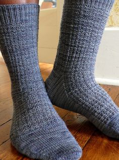 a person standing on a wooden floor with their feet up wearing socks that have been made from wool