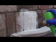 someone using a sponge to clean a brick wall