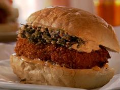 a fried chicken sandwich is on a white plate