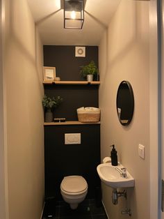 a bathroom with a toilet, sink and shelves on the wall in it's corner