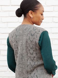 A lightweight cardigan, dress or jumper, and vest in ten sizes (XS/S/M/L/1X/2X/3X/4X/5X/6X) with subtle body shaping that flares below the waist to tunic or knee length. This button-down or pullover style to knit in a plant based blend or fine tweedy wool, is accented by vertical bands of mock cable texture with a touch of openwork. Matching Motifs: Woodfire Scarf, Illas Cies Pullover Suggested Yarns: Modern Deco Lace, Better Breakfast Fingering, Stone Soup Fingering, Shetlandia Fingering, Jacob Gray Fitted V-neck Sweater Vest, Fitted Casual Sweater Vest For Layering, Casual Fitted Sweater Vest For Layering, Fitted Sleeveless Cardigan For Layering, Fitted Gray Vest For Layering, Fitted Sweater Vest For Spring Layering, Fitted Sleeveless Cardigan For Fall, Versatile Fitted Vest For Fall, Elegant Stretch Vest For Fall