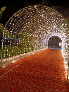 an archway covered in white lights and red carpet