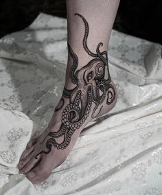 an octopus tattoo is on the foot of a woman's leg and it looks like she has been tattooed