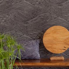 a wooden plate sitting on top of a table next to a plant