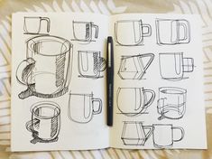 an open notebook with coffee mugs drawn on it and a pen resting in the middle