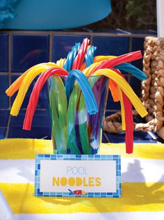 there is a vase filled with plastic straws on top of a yellow table cloth