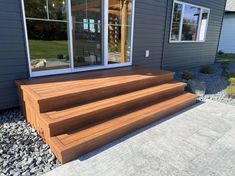 a wooden deck with steps leading up to the front door