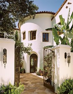 a white house with an iron gate in front