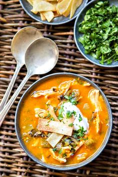 three bowls of soup with tortilla chips on the side