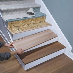 a man that is standing next to some stairs with wood flooring on top of it