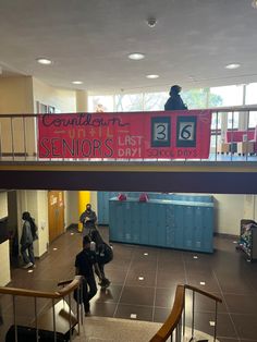 people are walking up and down the stairs in an indoor building with signs on it