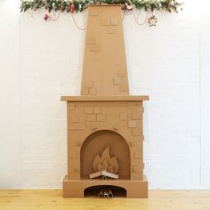 a cardboard fire place sitting on top of a wooden floor next to a white wall