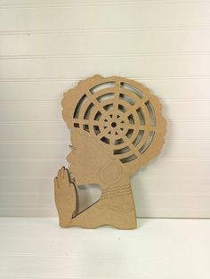 a wooden cutout of a woman's head with a fan on her head