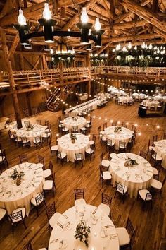 the inside of a barn with tables and chairs set up for an event or function