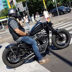 a man is sitting on his motorcycle in the street