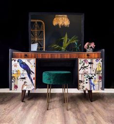 a green velvet stool sits in front of a desk with an art deco design on it