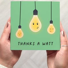 someone holding up a card with two light bulbs on it that says, thanks awatt