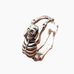 The ring's body is the human skeleton, which rings can adjust to fit your finger size. The overall color has been crafted into a brass color to add some retro style. The dark style of the skeleton and Halloween are the perfect partners, and this ring can also be worn daily and will give you a lot of personalities! Adjustable Punk Rings For Halloween, Vintage Metal Rings For Halloween, Gothic Adjustable Hand Cast Skull Ring, Vintage Adjustable Skull Ring For Halloween, Adjustable Vintage Skull Ring For Halloween, The Human Skeleton, Skeleton Ring, Bone Ring, Skeleton Bones