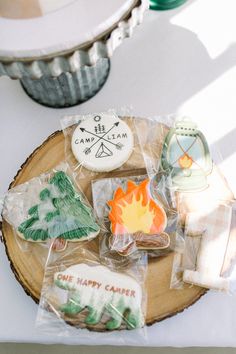 some cookies are sitting on top of a wooden plate with plastic wrappers around them