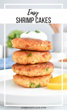 three crab cakes stacked on top of each other with lemon wedges in the background