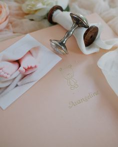 a baby's feet are being held up by a pair of tongs next to an album