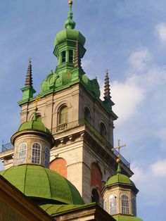 the top of a building with green domes and spires on it's sides