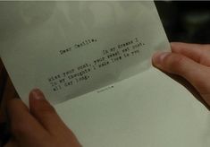 someone holding up a piece of paper with writing on it