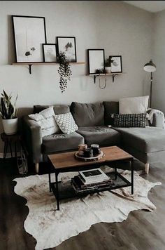 a living room with gray couches and pictures on the wall above them in black frames