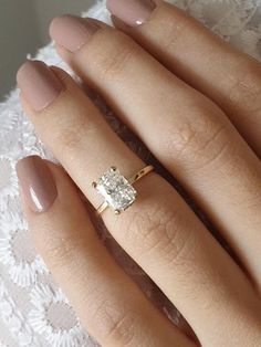 a woman's hand with a ring on it and a diamond in the middle