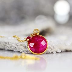 Back in stock! This striking Ruby necklace looks rich and exotic, and is perfect for adding colour to any outfit or occasion. Featuring a sparkling, round, cut and faceted ruby set in a bezel setting and paired with a dangling ruby gem. Available in various lengths. Rubies are the birthstone for July and the 40th wedding anniversary. Ruby jewelry makes a perfect romantic gift for a loved one, whether for a birthday, anniversary or Valentine's Day, as Rubies have always been associated with love Spiritual Gemstone Necklaces For Celebration, Unique Ruby Gemstone Necklace, Unique Faceted Jewelry For Gifts, Party Jewelry With Birthstone, Gemstone Necklace With Round Pendant For Celebration, Handmade Ruby Jewelry For Gift, Ruby Briolette Gemstone Jewelry, Ruby Birthstone Necklaces, Red Faceted Pendant Necklaces