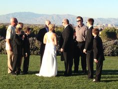 a group of people standing on top of a lush green field next to each other