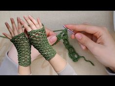 two hands crocheting together with green yarn