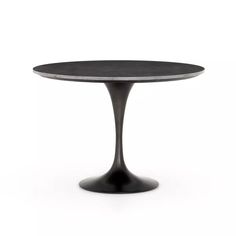 an oval dining table with black marble top and pedestal base, viewed from the front