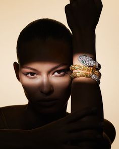 a woman holding her hands up to her face with two bracelets on each arm