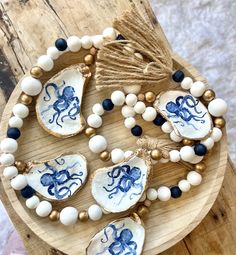 an octopus necklace with white and blue beads on a wooden board next to other items