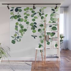 green leaves on white wall mural in living room with wood flooring and wooden ladder