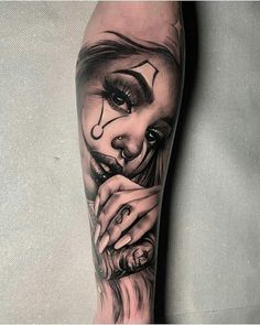 a woman's leg with a tattoo on it and her face painted in black ink