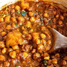 a wooden spoon in a pot filled with chickpeas