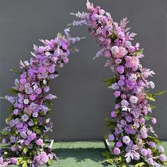 purple flowers are arranged in an arch on the ground