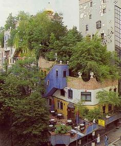 an aerial view of a house with trees growing on the roof and people walking around