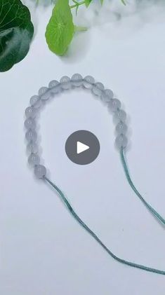 the video shows how to make a beaded bracelet with beads and green leafy leaves