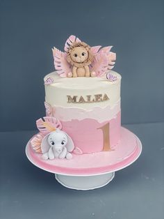 a pink and white cake with an elephant on top